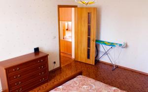 ニジネカムスクにあるЛюкс Апартаменты на Баки Урманче 9のドレッサー付きの部屋、ベッドルームへのドア