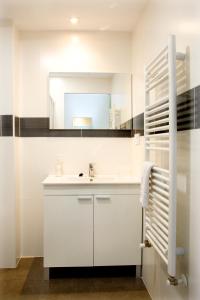 a white bathroom with a sink and a mirror at Imprenta Musical Alojamiento in Astorga +42 photos