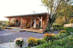 a small cabin with a porch in a garden at Gartenloft Ruheoase in Kleinotten