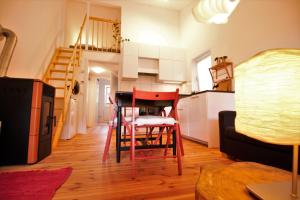 ein Wohnzimmer mit einem roten Stuhl und eine Küche in der Unterkunft Gartenloft Ruheoase in Kleinotten