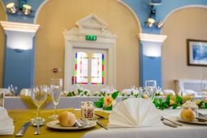una mesa con manteles blancos y copas de vino en Castle Hotel, en Tamworth