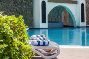 a blue chair sitting in front of a pool of water at Marbella Resort in Sharjah