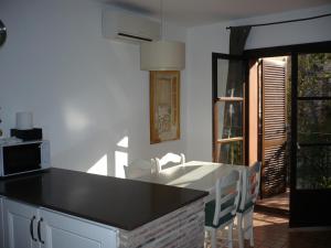 タラゴナにあるApartamento con Encanto Ferrersのキッチン(黒いカウンタートップ、テーブル付)