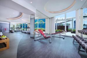 a gym with red chairs and large windows at DAMAC Maison Distinction in Dubai