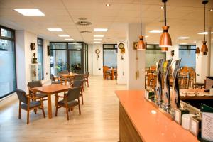 a restaurant with tables and chairs and a counter at Imprenta Musical Alojamiento in Astorga