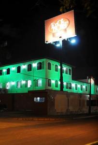 a building is lit up in green at night at Eros Hotel CDU (Adults Only) in Recife