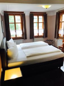 a large bed in a bedroom with windows at Zum Fehmelbauer in Karlstadt