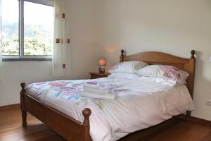 a bedroom with a bed with white sheets and a window at OurMadeira - ArcoView in Calheta +14 photos