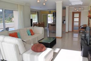 a living room with two white couches and a table at OurMadeira - Villa Dilis, informal in Calheta