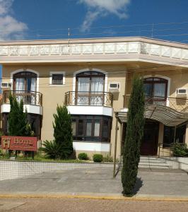 a yellow building with a sign in front of it at Hotel Recanto do Imperador in Rio Pardo