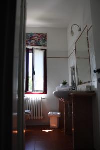 baño con lavabo y ventana en Villa Belfiore, en Ostellato