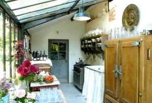a kitchen with a table with glasses and flowers at Le Moulin Bregeon in Linières-Bouton