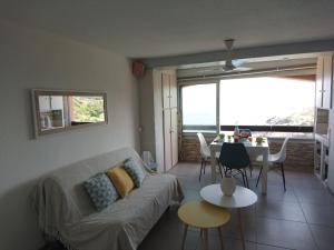 a living room with a couch and a table at Portvendres Sea view in Port-Vendres