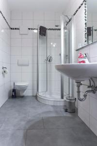 a bathroom with a sink and a shower and a toilet at Landgasthof Schmalhofer in Tittling