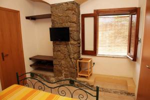 a bedroom with a bed and a stone wall at Residenza Casale San Francesco free parking in Tropea