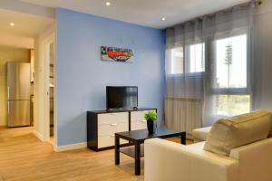 a living room with a couch and a tv at Apartamentos San Lázaro in Zaragoza