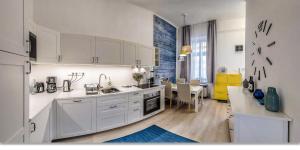ブダペストにあるStunning Oktogon Homeの白いキャビネット付きのキッチン、ダイニングルーム