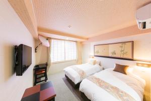 a hotel room with two beds and a tv at Kyoto Inn Gion The Second in Kyoto