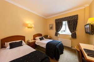 a hotel room with two beds and two lamps at Prince Rupert Hotel in Shrewsbury