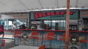 a restaurant with red chairs and a counter with a skull and bones mural at Guesthouse Porec in Poreč