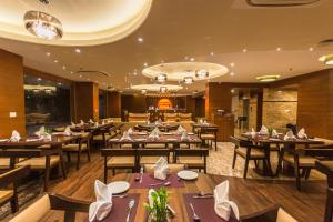 a restaurant with wooden floors and tables and chairs at Hotel Udai Median in Udaipur