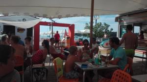 a group of people sitting at tables on the beach at Guesthouse Porec in Poreč