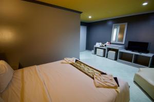 a bedroom with a bed and a tv in a room at The Little Moon Residence in Patong Beach