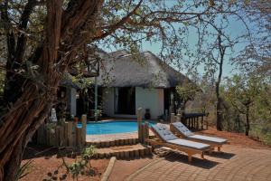 a resort with a swimming pool and a house at Lions Place in Grietjie Game Reserve