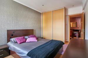 a bedroom with a bed with purple pillows on it at In Bed with Lisbon 4E in Amadora