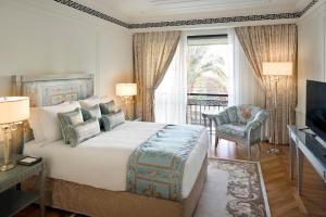a bedroom with a large bed and a television at Palazzo Versace Dubai in Dubai