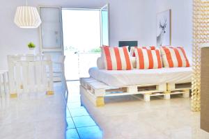 a bedroom with a bed with orange and white pillows at Villa Alba in Acitrezza