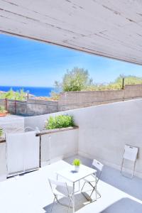 a patio with a table and chairs and the ocean at Villa Alba in Acitrezza