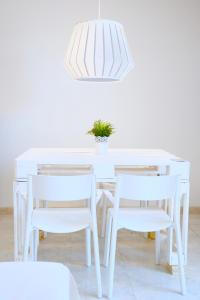 a white table and chairs with a potted plant on it at Villa Alba in Acitrezza