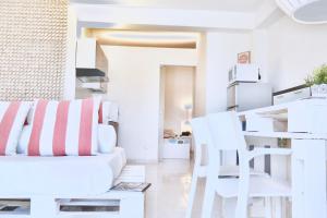 a white living room with white chairs and a couch at Villa Alba in Acitrezza