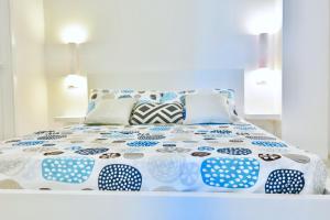 a bed with blue and white sheets and pillows at Villa Alba in Acitrezza