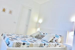 a bedroom with a bed with a blue and white comforter at Villa Alba in Acitrezza
