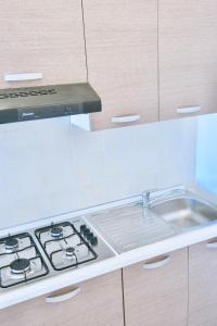a kitchen with a stove and a sink at Villa Alba in Acitrezza