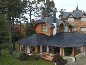 a house with a black roof on top of it at HTL La Malinka in San Carlos de Bariloche