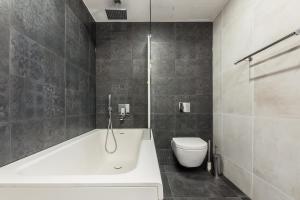 a bathroom with a white tub and a toilet at Tallinn Premium Apartments in Tallinn +66 photos