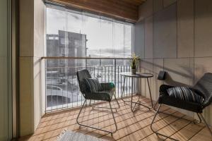 d'un balcon avec deux chaises, une table et une fenêtre. dans l'établissement Tallinn Premium Apartments, à Tallinn