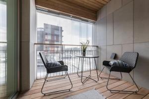 a balcony with two chairs and a table in front of a window at Tallinn Premium Apartments in Tallinn