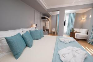 a large white bed with blue pillows and towels on it at Aenos Hotel in Argostoli