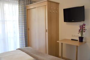 a bedroom with a bed and a cabinet with a television at Appartement Romana - Altstadt in Schladming