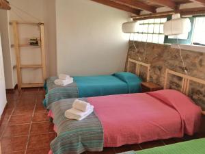 Habitación con 3 camas y toallas. en Casas da Lagoa, en Santo Isidoro