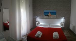 a bedroom with a red bed with a red blanket at La Bella Vita in San Vito dei Normanni