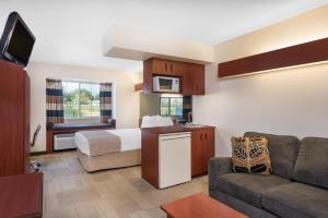 una camera d'albergo con un letto e un divano di Microtel Inn & Suites by Wyndham Sainte Genevieve a Sainte Genevieve