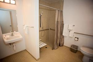uma casa de banho com um chuveiro, um lavatório e um WC. em Motel 6-Crescent City, CA em Crescent City