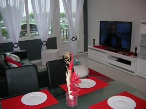 Gite Seine في رووين: غرفة معيشة مع طاولة وتلفزيون