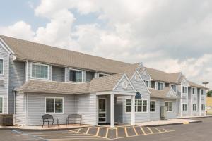 un edificio bianco con tetto grigio di Microtel Inn & Suites by Wyndham Sainte Genevieve a Sainte Genevieve
