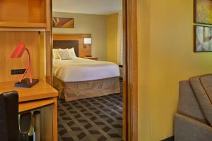 a hotel room with a bed and a mirror at Residences at Tewksbury in Tewksbury